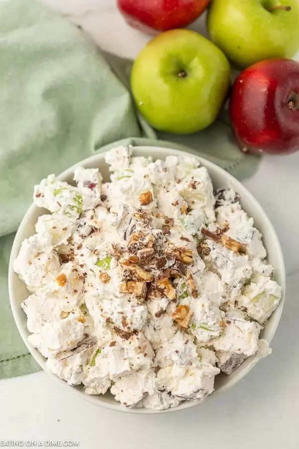 a white bowl filled with food next to apples