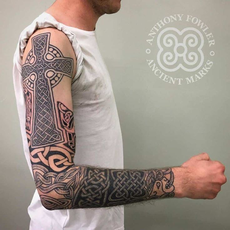 a man with a cross tattoo on his arm