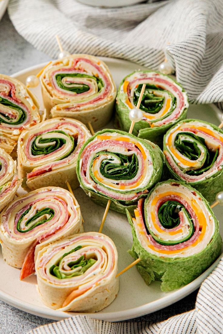 a plate filled with rolls and veggies on skewers