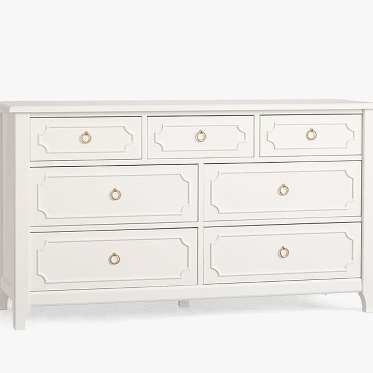 a white dresser with gold handles and drawers on it's sides, against a white background