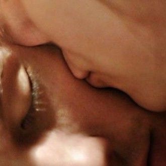 a man and woman kissing each other with their noses close together