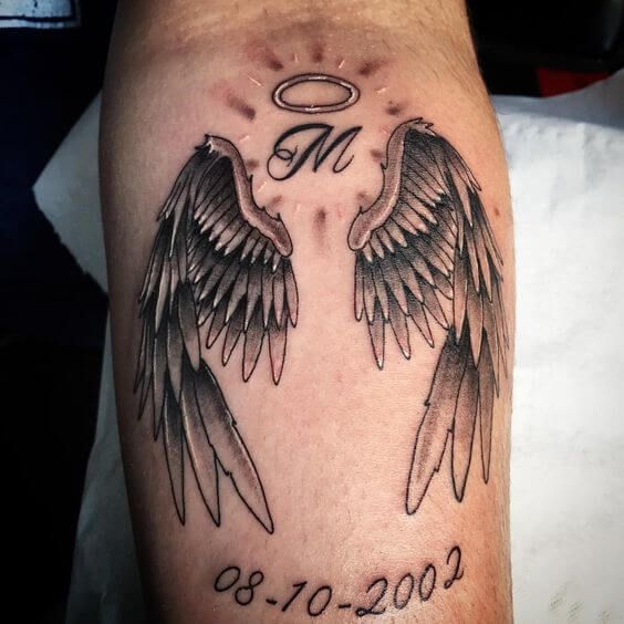 two black and white wings with an angel in the middle on a man's leg