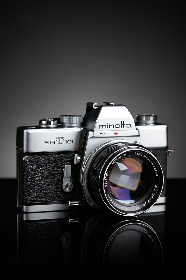 an old style camera sitting on top of a black table with its lens up to the side