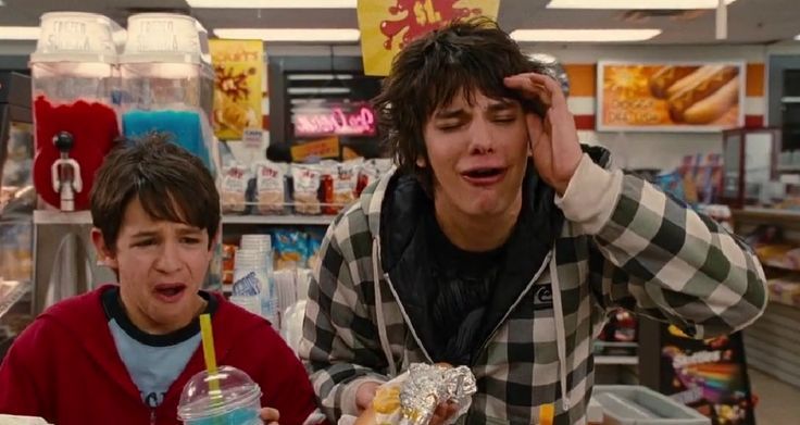 two young boys in a grocery store looking at food