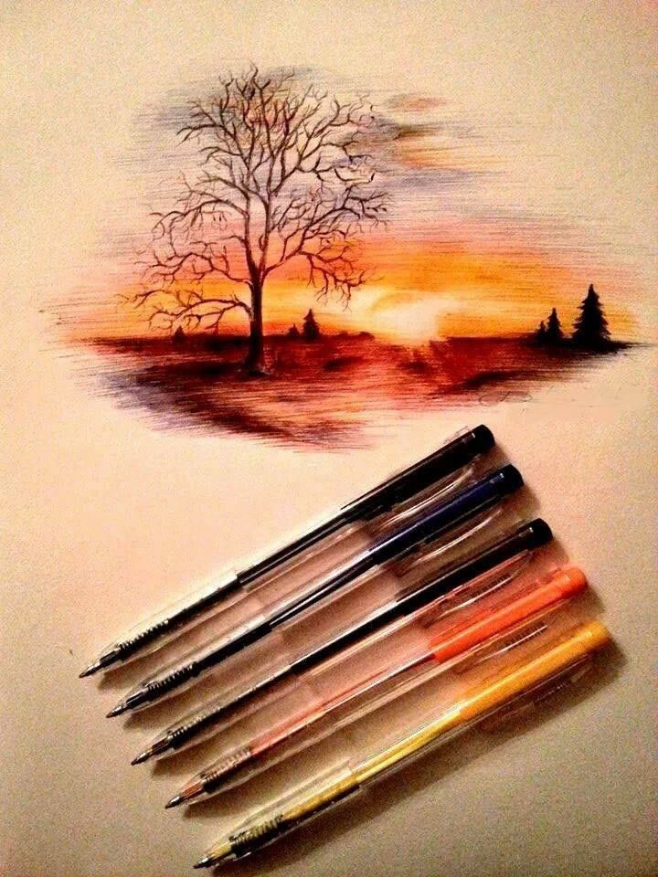 some watercolor pencils are laying on top of a piece of paper with a tree painted on it