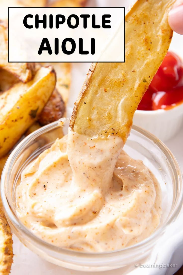 a person dipping some chips into a small glass bowl with dip in it and the words chipotle aioli above them