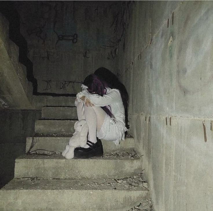 a person sitting on some steps in the dark