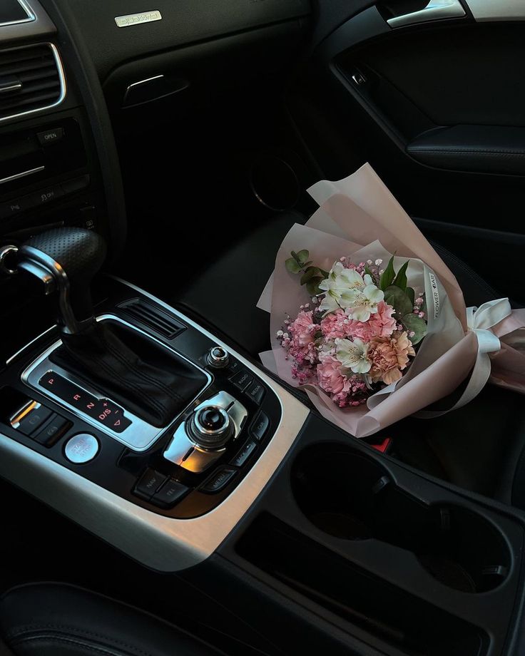 a bouquet of flowers sitting in the center console of a car