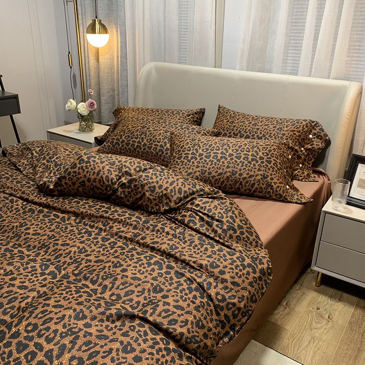 a leopard print comforter set on a bed