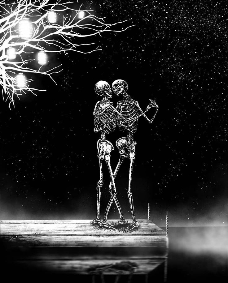 two skeletons standing next to each other in front of a tree with lights on it