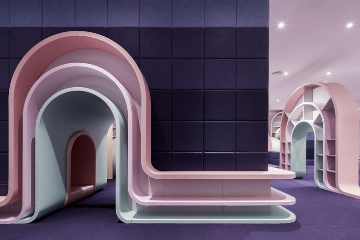 the interior of a building with pink and purple walls, arched doorways and shelves