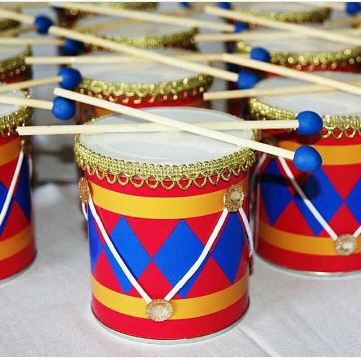 several drums with sticks sticking out of them sitting on a white tablecloth covered table