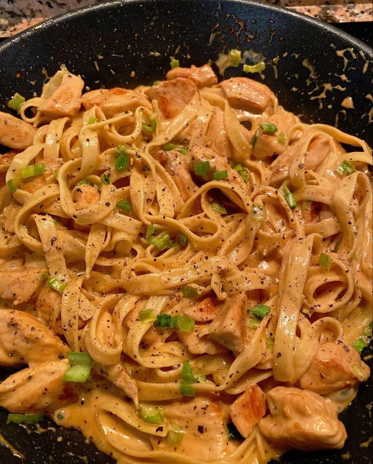 pasta with chicken and green onions in a skillet