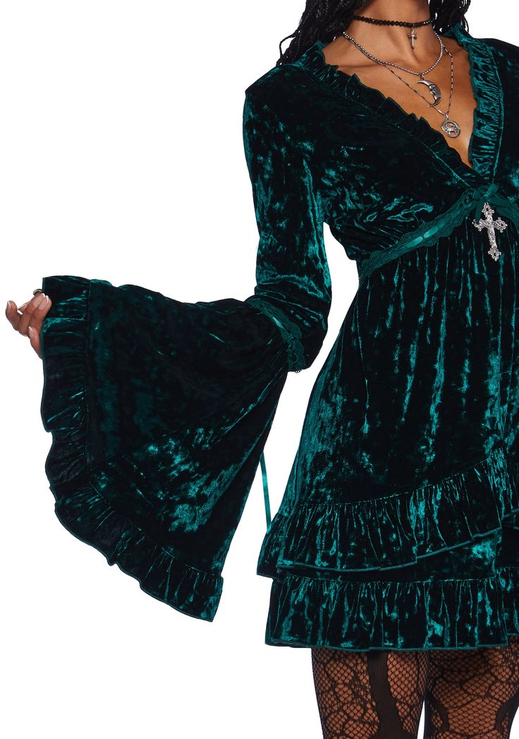 Be heavenly in this stretchy crushed velvet mini dress which has tiered bell sleeves, interlocking ribbon detailing, a ruffled trim, a plunging neckline, a cross charm on the front, and a tiered skirt. Velvet Ruffle Mini Dress, Charmed Fashion, Fall Mini Dress, Green Goth, Velvet Green Dress, Emerald Green Velvet Dress, Magic Clothes, Velvet Dress Short, Emerald Velvet