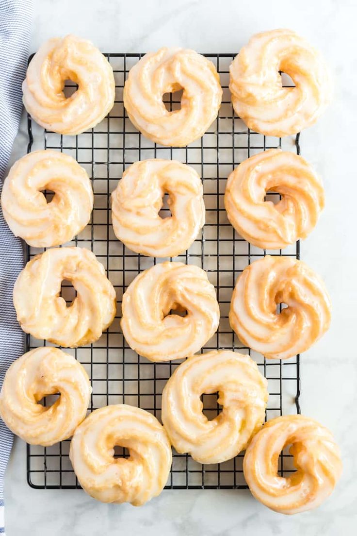 glazed donuts on a cooling rack ready to go into the oven for baking in the oven