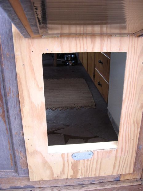 an unfinished wooden cabinet with a mirror in it's center and the door open