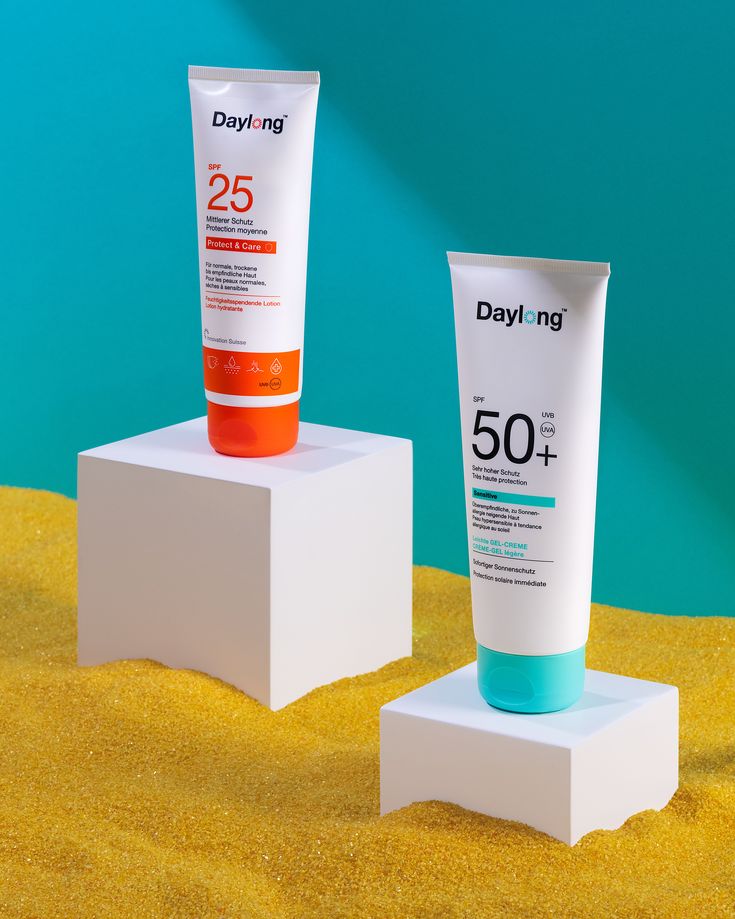 two sunscreens sitting on top of each other in front of a blue and green background