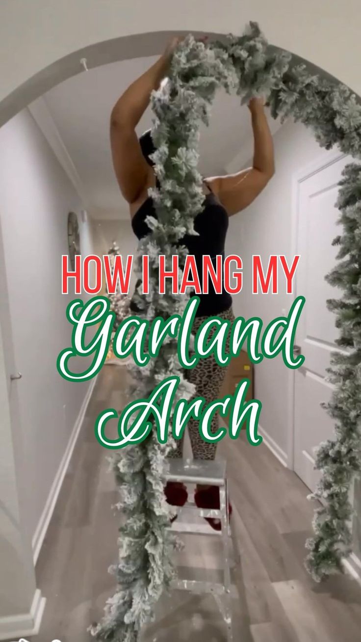 a woman standing on top of a ladder in front of a christmas wreath with the words how i hang my garland arch