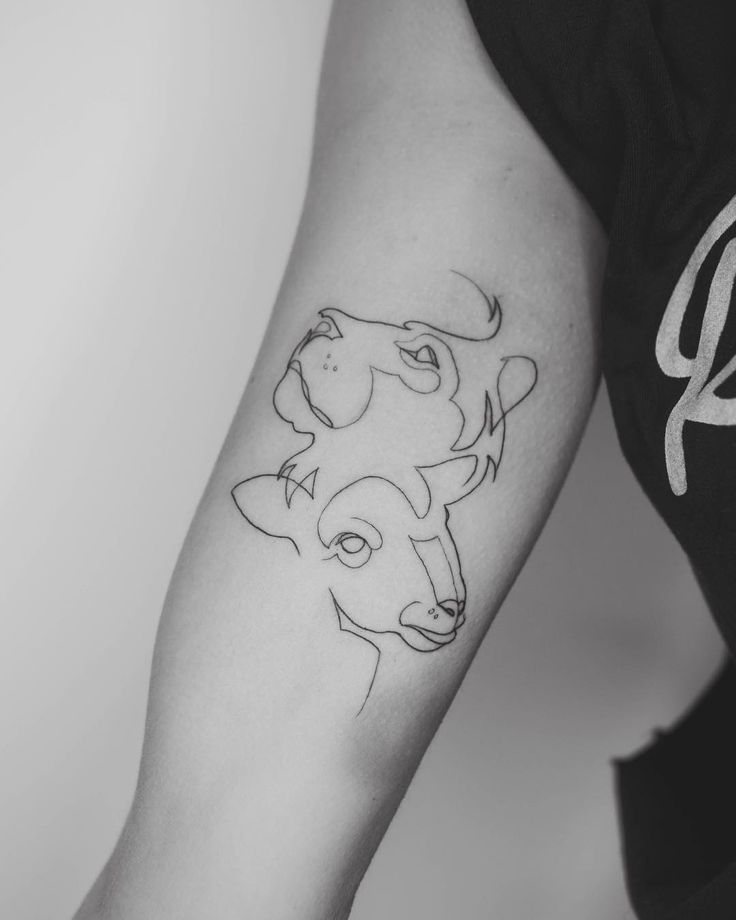 a black and white photo of a woman's arm with a tattoo on it