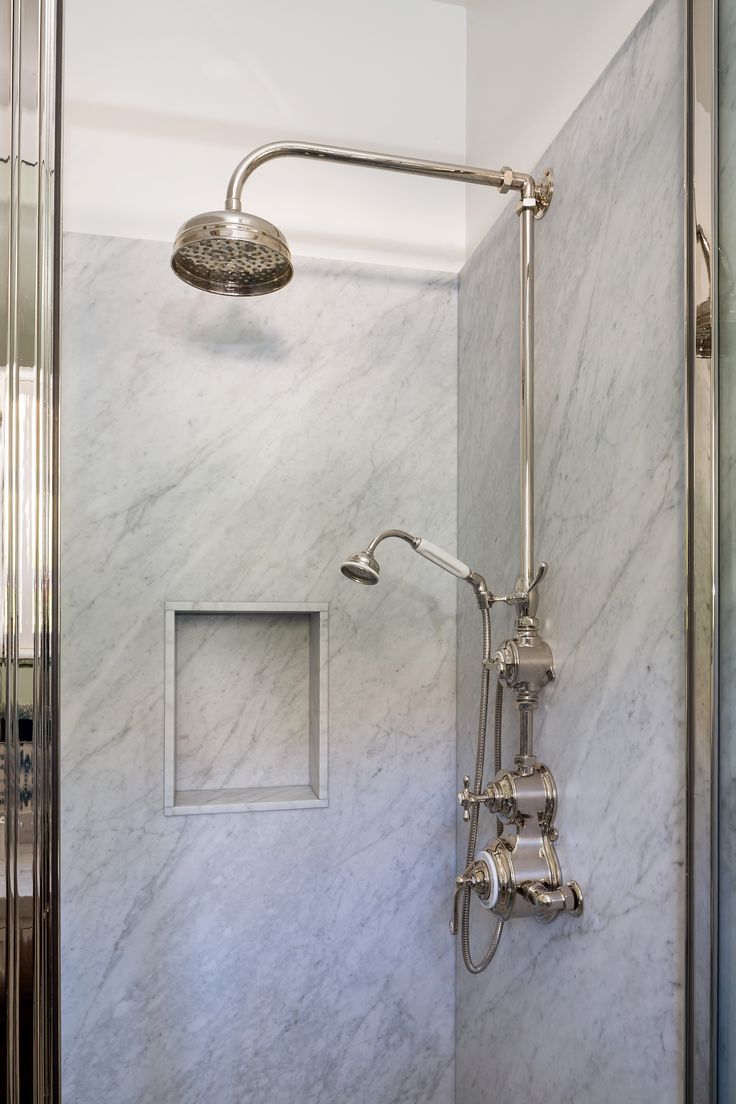 a bathroom with marble walls and shower head