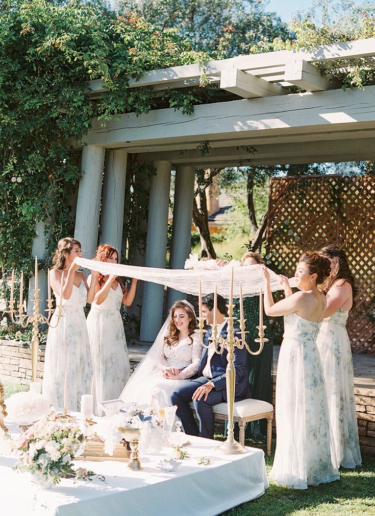 a group of women standing next to each other in front of a table with food on it