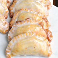 some kind of pastry with icing on it sitting on a white table cloth next to a fork