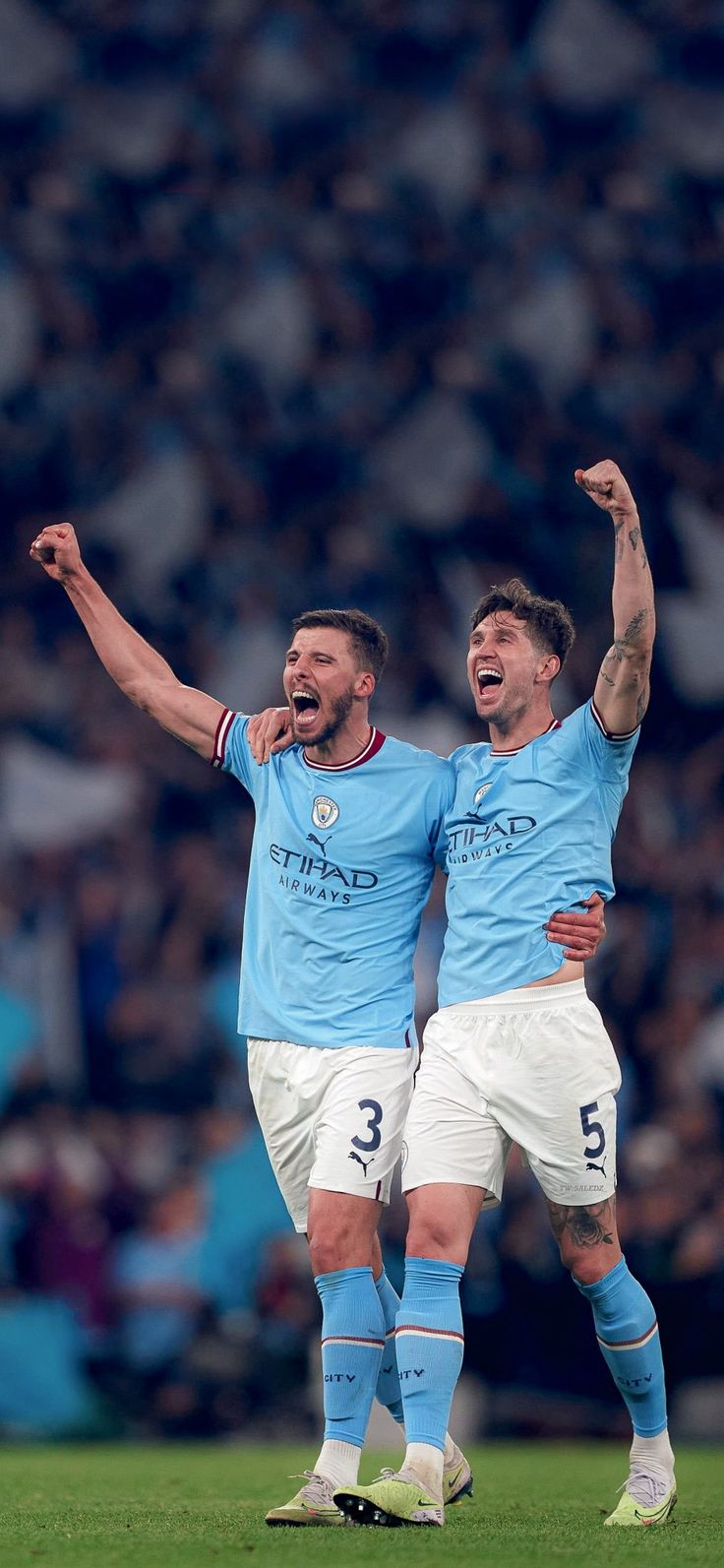 two soccer players are celebrating on the field