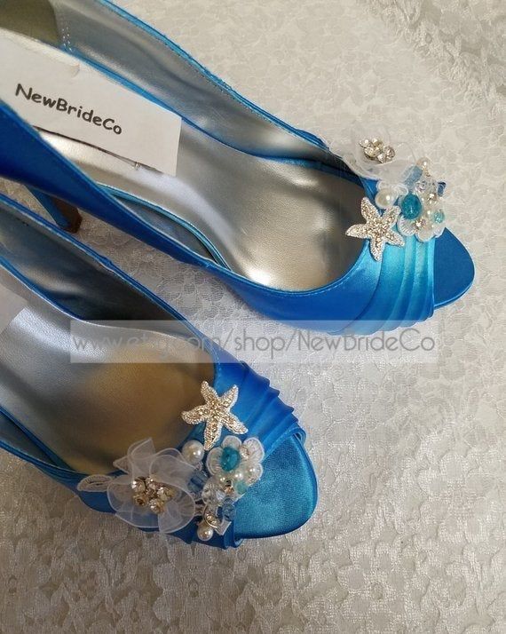 two pairs of blue shoes with flowers on the toes and one has a name tag that says new bride