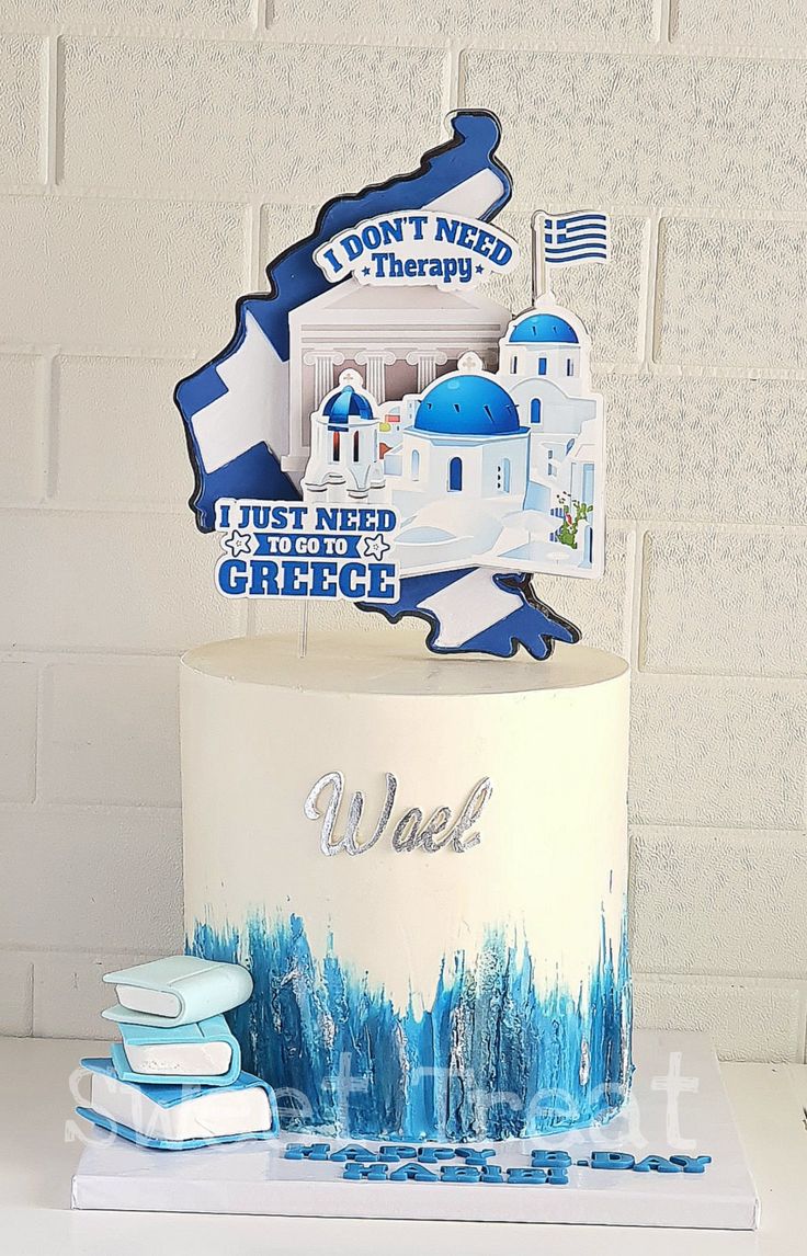 a cake with blue and white decorations on it sitting on top of a table next to books