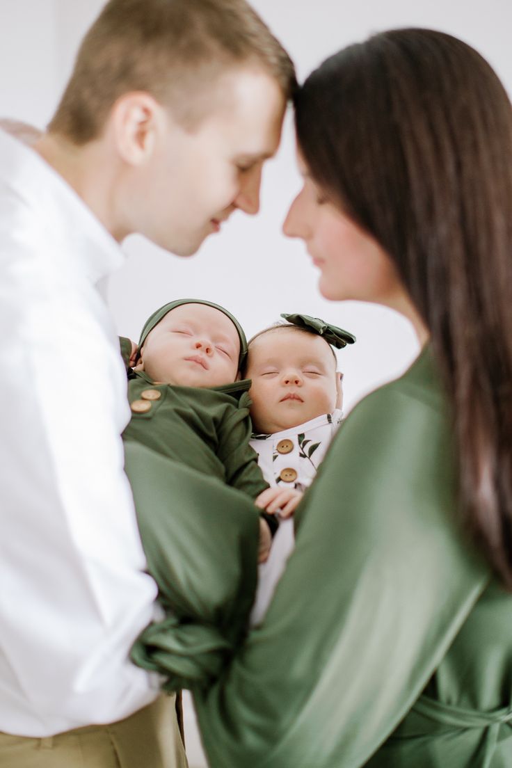 a man and woman holding a baby in their arms