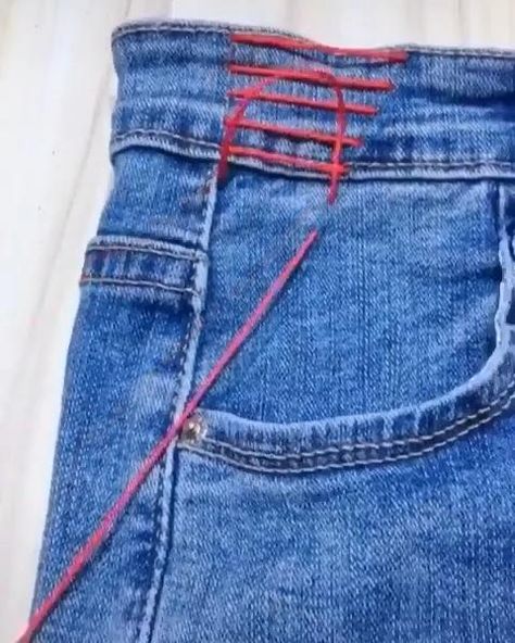 a pair of blue jeans with red string on them