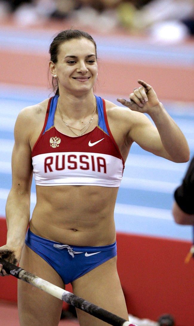 a woman holding a pole in her hand and wearing a red top with russian writing on it