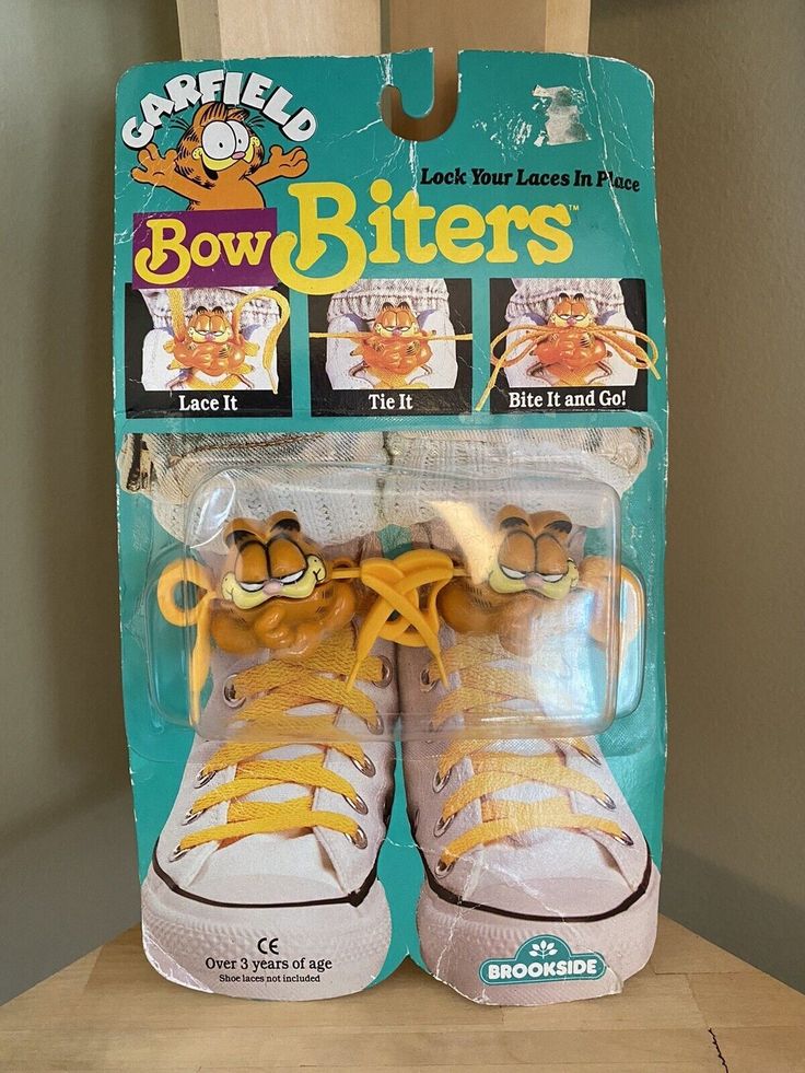 a pair of yellow and white shoes sitting on top of a wooden table in front of a box