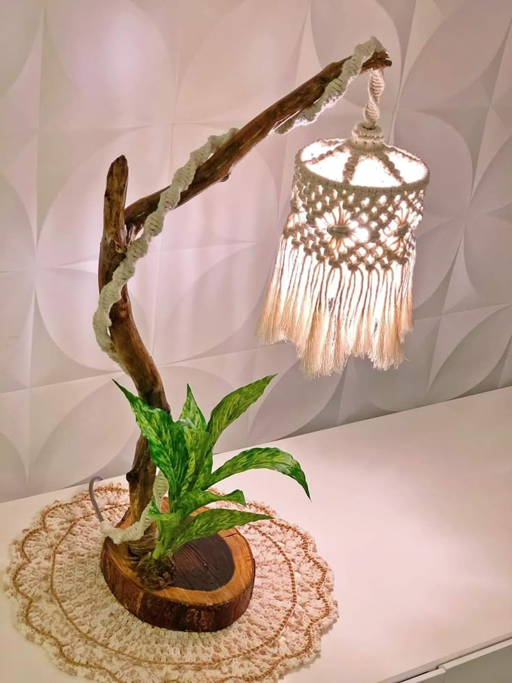 a lamp that is on top of a table with a potted plant in it