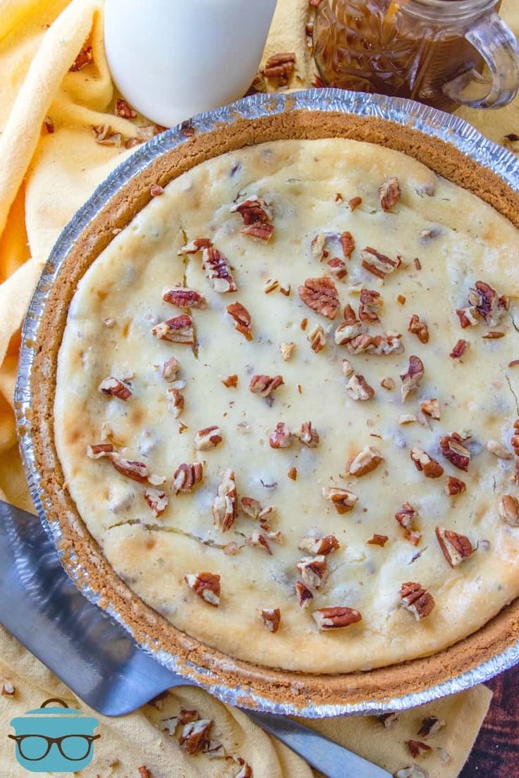 a pie sitting on top of a pan covered in pecans next to crackers