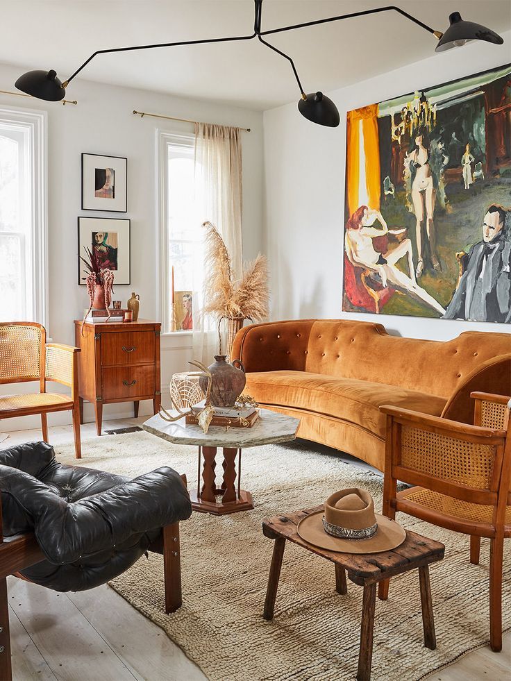 a living room filled with lots of furniture and art on the wall next to windows