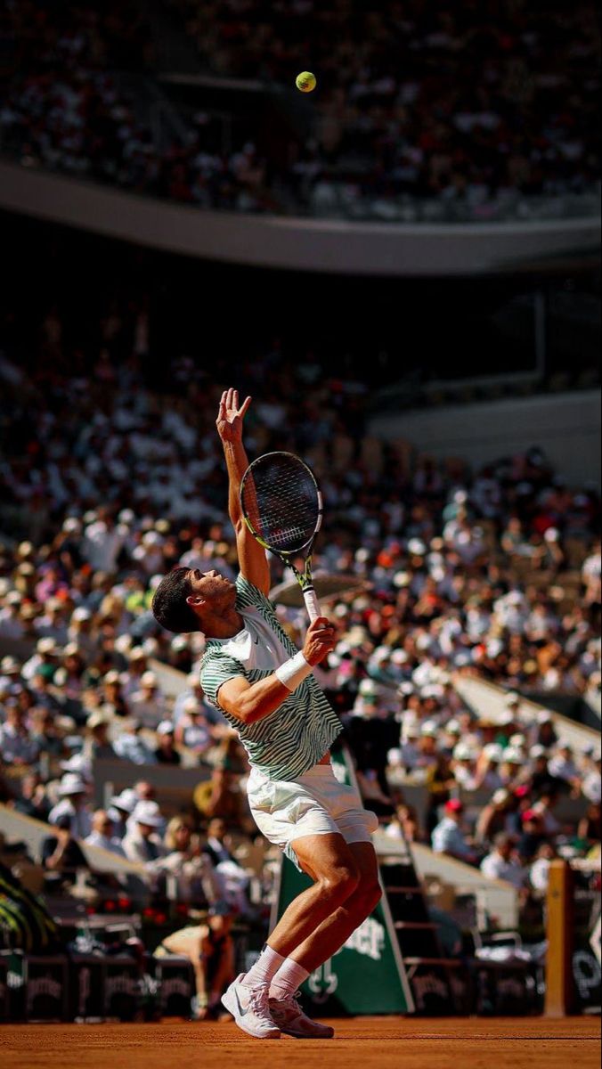 a male tennis player is in the middle of serving the ball to his opponent during a match