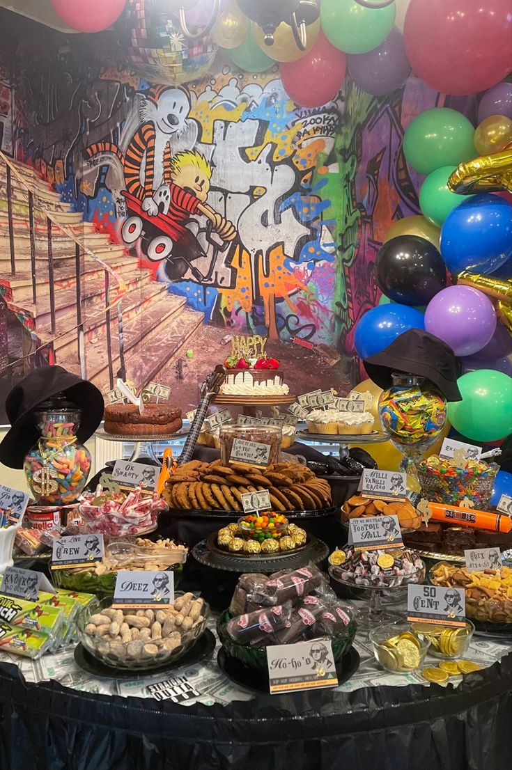 a table topped with lots of food and balloons