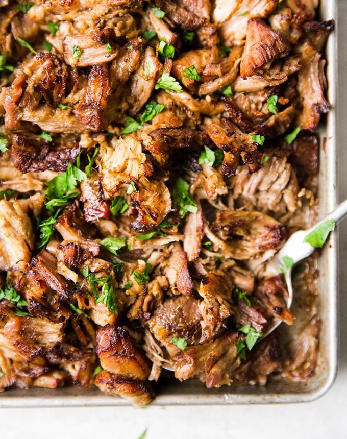 a pan filled with meat and garnished with parsley