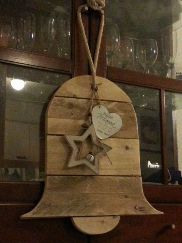 a wooden bell with a star hanging from it's side and a rope attached to the front