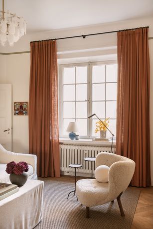 a living room filled with furniture and a chandelier hanging from the ceiling next to a window