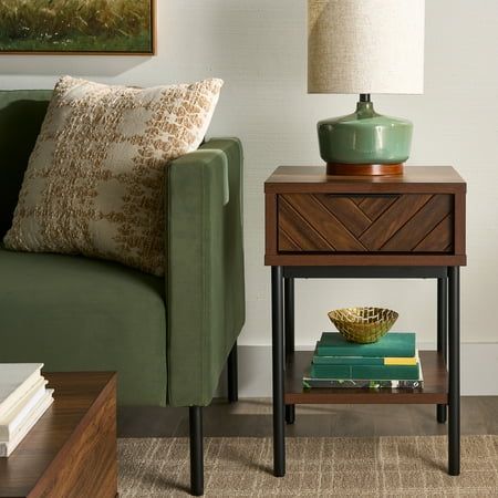 a living room with a couch, table and lamp on the end table in front of it