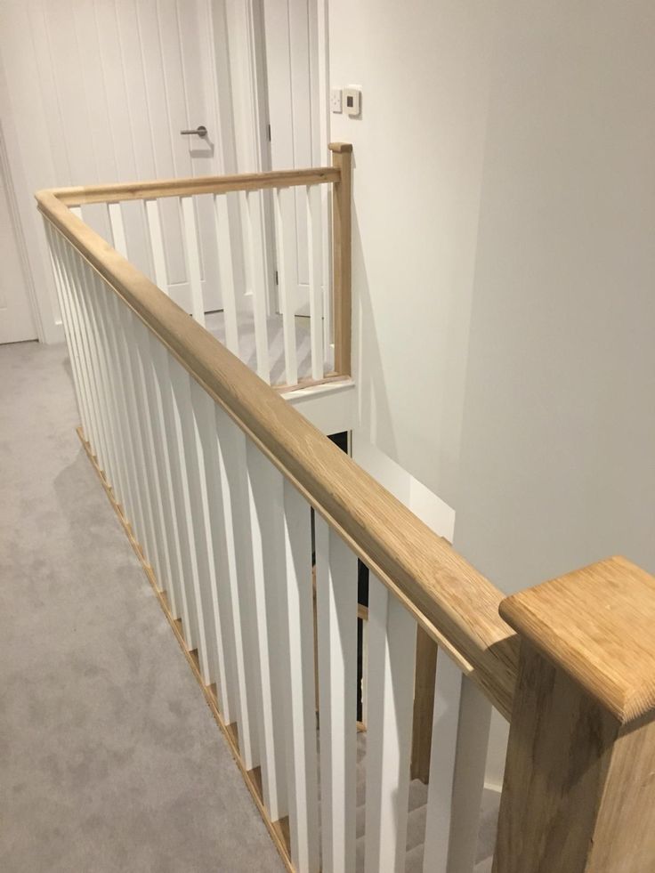 a wooden banister next to a white wall