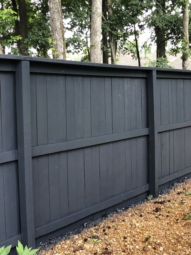 a wooden fence in front of some trees