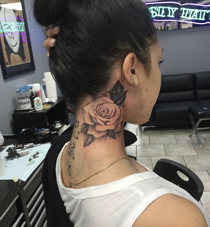 a woman with a rose tattoo on her neck