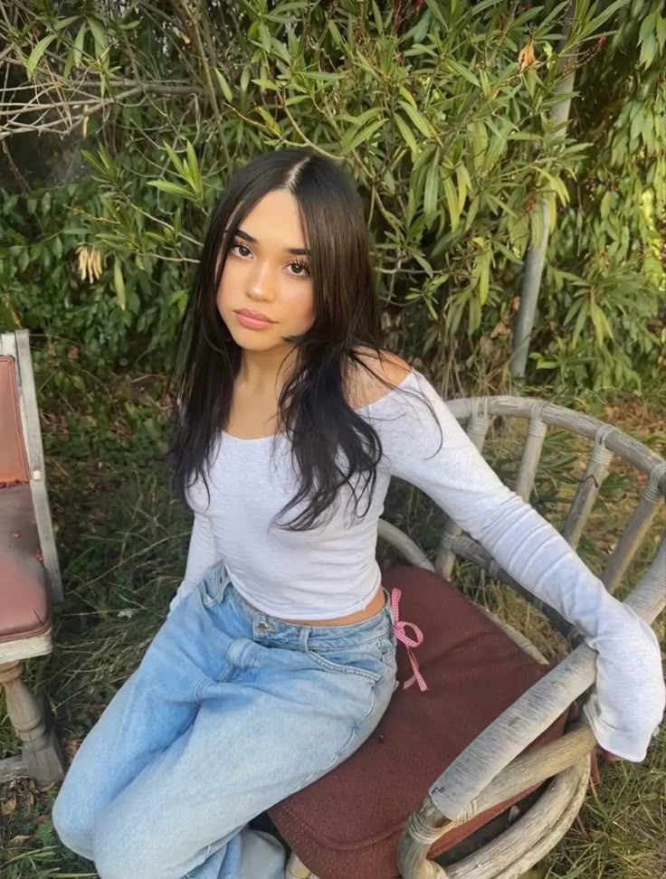 a woman sitting on top of a wooden chair