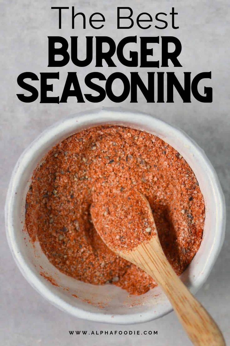 the best burger seasoning recipe in a white bowl with a wooden spoon on top