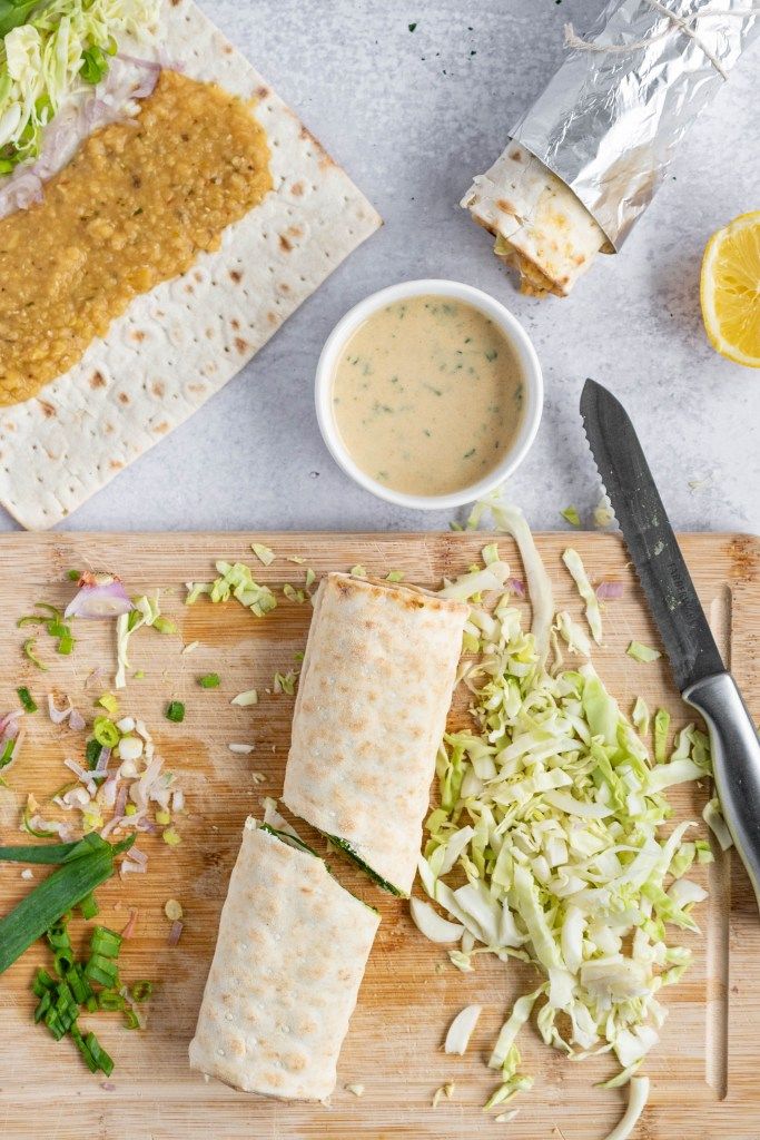 the recipe for spicy lentil wrap is shown on a cutting board with a knife