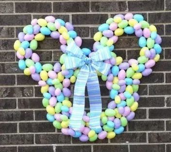 a mickey mouse made out of candy on the side of a building with a blue bow