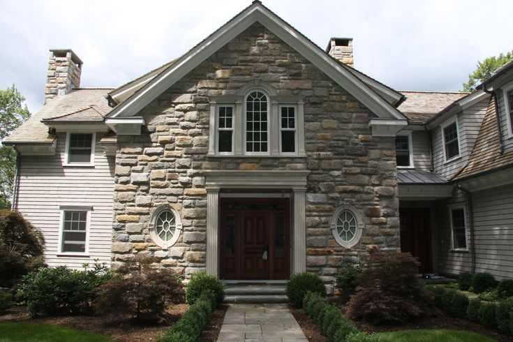 a stone house with white trim and windows